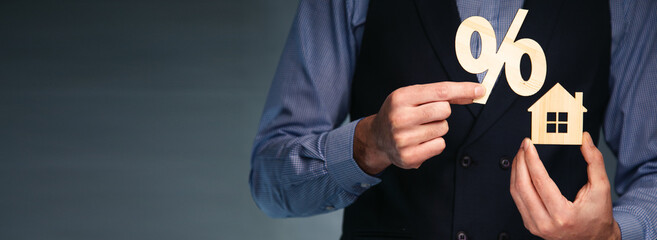 man holding percent with house model