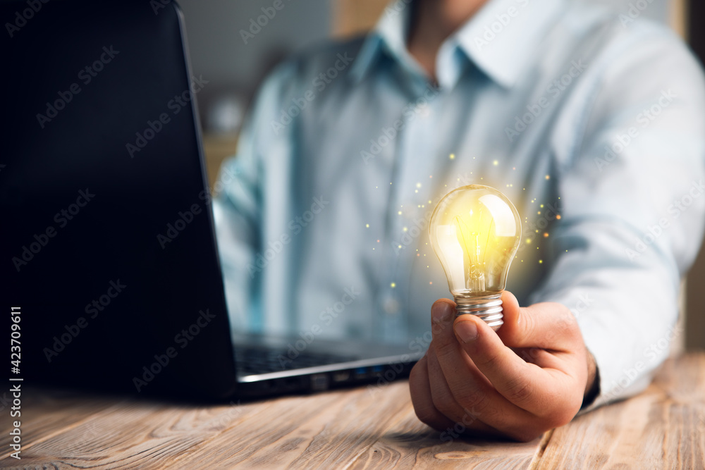 Poster hand with a lightbulb with a computer