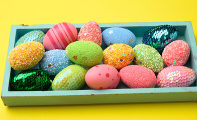 decorative easter eggs on a yellow background, top view