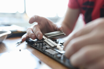 Master conducting diagnostics of video card in workshop closeup
