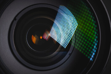Close-up of the front lens of a DSLR camera lens with flare from a light source