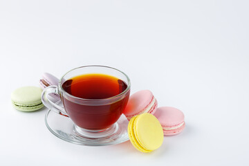 Cup of tea and colorful macaroons on a white background.