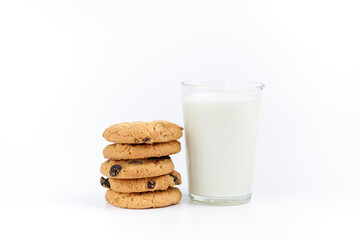 A glass of milk and cookies with raisins on a white background