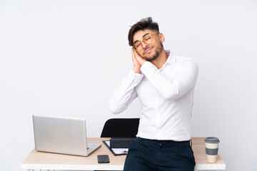 Arabian man in a office isolated on white background making sleep gesture in dorable expression