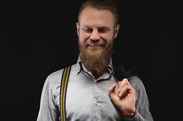 successful young man with a beard in a shirt smiling, portrait, black background