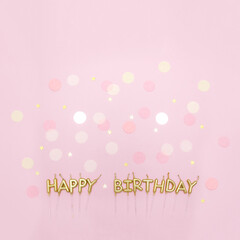 Happy birthday golden candles on pink background decorated with confetti. Minimal anniversary concept. Copy space, top view