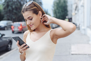 Happy successful smiling woman using smart phone for shopping online on outdoor street background. Close up