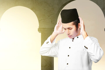 Asian Muslim man in praying position (salat)