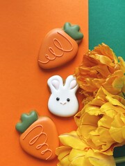 Cute white Easter bunny cookie with orange tulips 