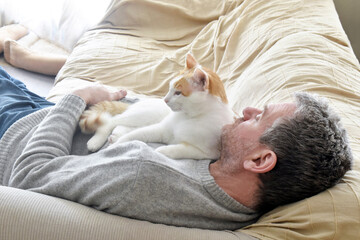 Cat laying on owner's chest. Unconditional love between cat and human concept. Cat and owner...
