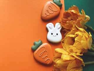 Cute white Easter bunny cookie with orange tulips 