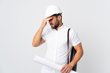 Young architect man with helmet and holding blueprints isolated on white background with headache