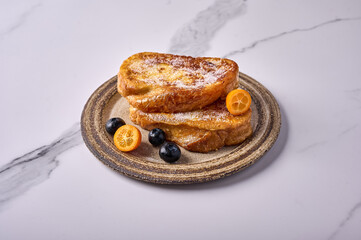 Homemade traditional Spanish torrijas or French toast with kumquats and blueberries. Popular dessert for Christmas, Easter or Pascua