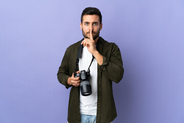 Naklejka premium Photographer man over isolated purple background showing a sign of silence gesture putting finger in mouth