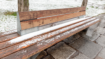 Wooden bench in a park on a snowy day