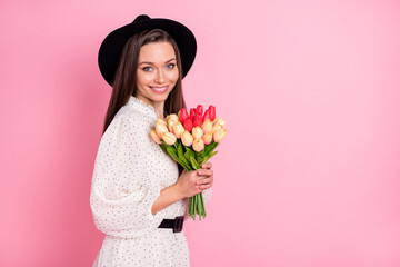Profile photo of adorable cheerful girl arms hold flowers wear retro cap isolated on pink color background