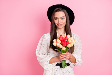 Portrait of gorgeous person hands hold flowers wear vintage cap look camera isolated on pink color background
