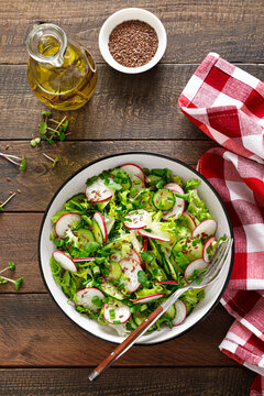 Radish and cucumber salad with fresh green onion in bowl