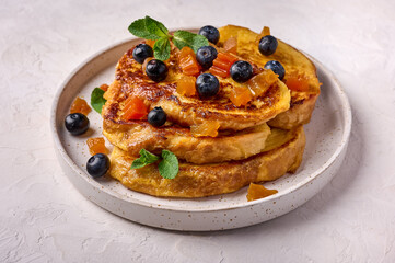 Homemade traditional Spanish torrijas or French toast with melon candied fruit and blueberries. Popular dessert for Christmas, Easter or Pascua. Close up