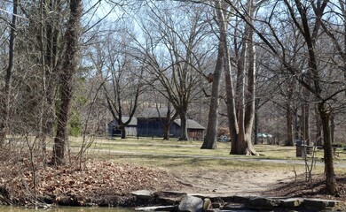 The view of the old wood barn in the wooded area.