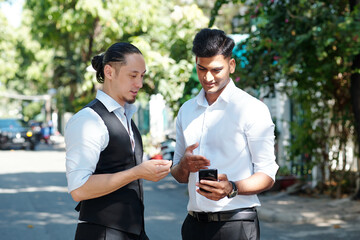 Financial brokers standing outdoors and discussing latest updates from financial news networks