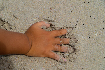 child on the beach. boy's hand on beach while playing in the send