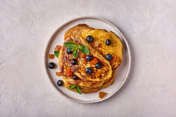 Homemade traditional Spanish torrijas or French toast with melon candied fruit and blueberries. Popular dessert for Christmas, Easter or Pascua. Top view