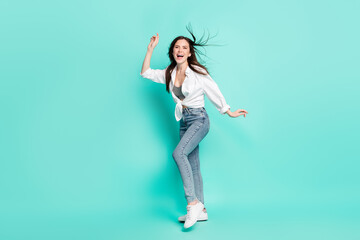 Fototapeta na wymiar Full length photo of attractive young cheerful lady enjoy weekend fly hair smile isolated on teal color background