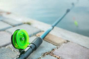 Fototapeta na wymiar Fishing rod on river bank, closeup