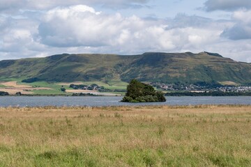 Fototapeta na wymiar Landscape of Loch Leven, small island and mountain range in background near Kinross, Scotland