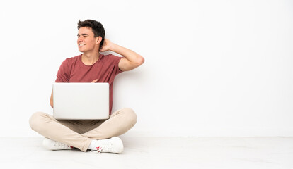 Teenager man sitting on the flor with his laptop with neckache