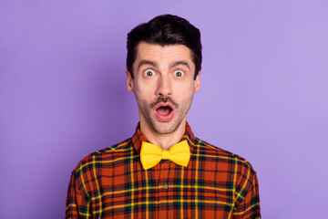 Portrait of attractive amazed stunned funky guy wearing checked shirt opened mouth isolated over violet purple color background