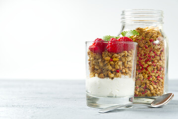 Yogurt with granola and fresh blueberries and raspberry, in glass. Healthy breakfast: yogurt parfait with granola and berries