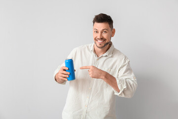 Handsome man with soda on light background
