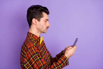 Profile photo of serious guy hold telephone look screen wear bow tie plaid shirt isolated violet background