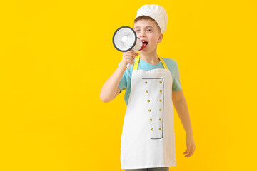 Little chef with megaphone on color background