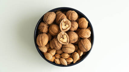 almonds and walnuts in a plate on a white background