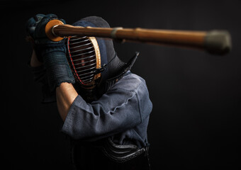 Portrait of Kendo master standing in fighting stance.He practising with shinai.