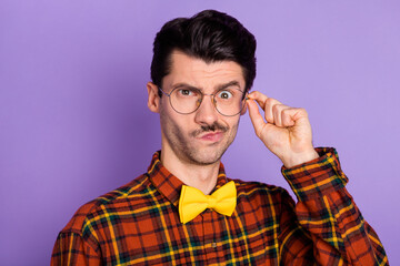 Photo of attractive doubtful young man dressed checkered shirt arm glasses isolated purple color...