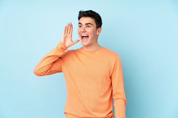 Teenager caucasian handsome man isolated on purple background shouting with mouth wide open