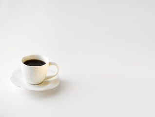 Drunk cup of strong coffee with coffee spent grounds on saucer with spoon against white background, top view with place for text