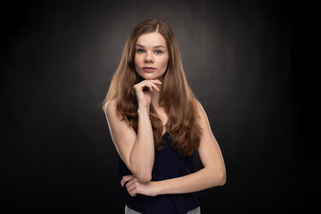 Young woman - student with smartwatch - looking into the camera lens - studio shoot on the black background 