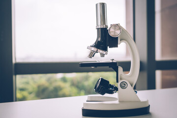 The microscope is located on a glass laboratory table.