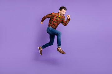 Fototapeta na wymiar Profile photo of crazy guy jump hurry fast run empty space wear bow tie plaid shirt jeans shoes isolated purple background