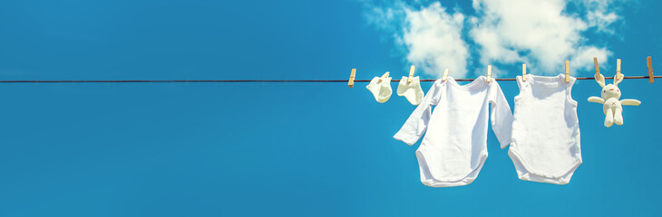 White baby clothes dry on a rope. Selective focus.