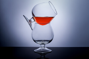 Cognac glasses with a drink on a dark background. Dishes for cognac and other drinks.