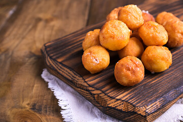Baked castagnole with powdered sugar on wooden background. Street food, round biscuits with sugar for the carnival of Venice. Traditional sweet pastries during the carnival period in italy. copy space