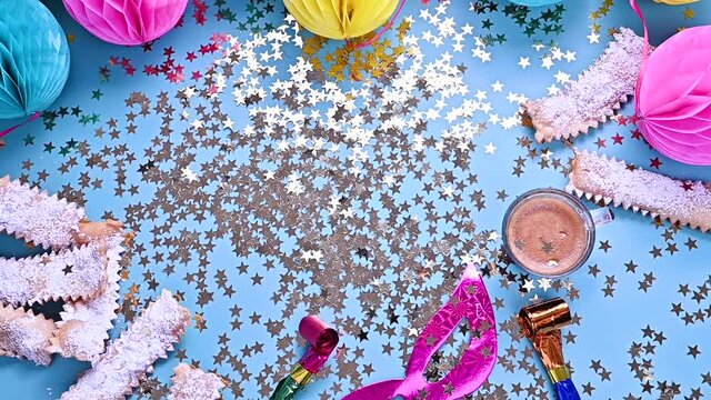 Falling confetti and sparkles. Traditional Venetian carnival and food TYPICAL. Coffee, Sfrappole or chiachiere or angel wings and aromatic coffee on a bright blue background. Copy space