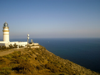 Fototapeta na wymiar white lighthouse on top of a hill with ocean view
