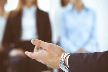 Businessman making presentation to group of people in office. Speaker delivering a seminar to his colleagues or business training. Teamwork and coaching concepts in business